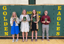 Winners of the Science Fair holding their plaques while standing in front of the Golden Eagle mats
