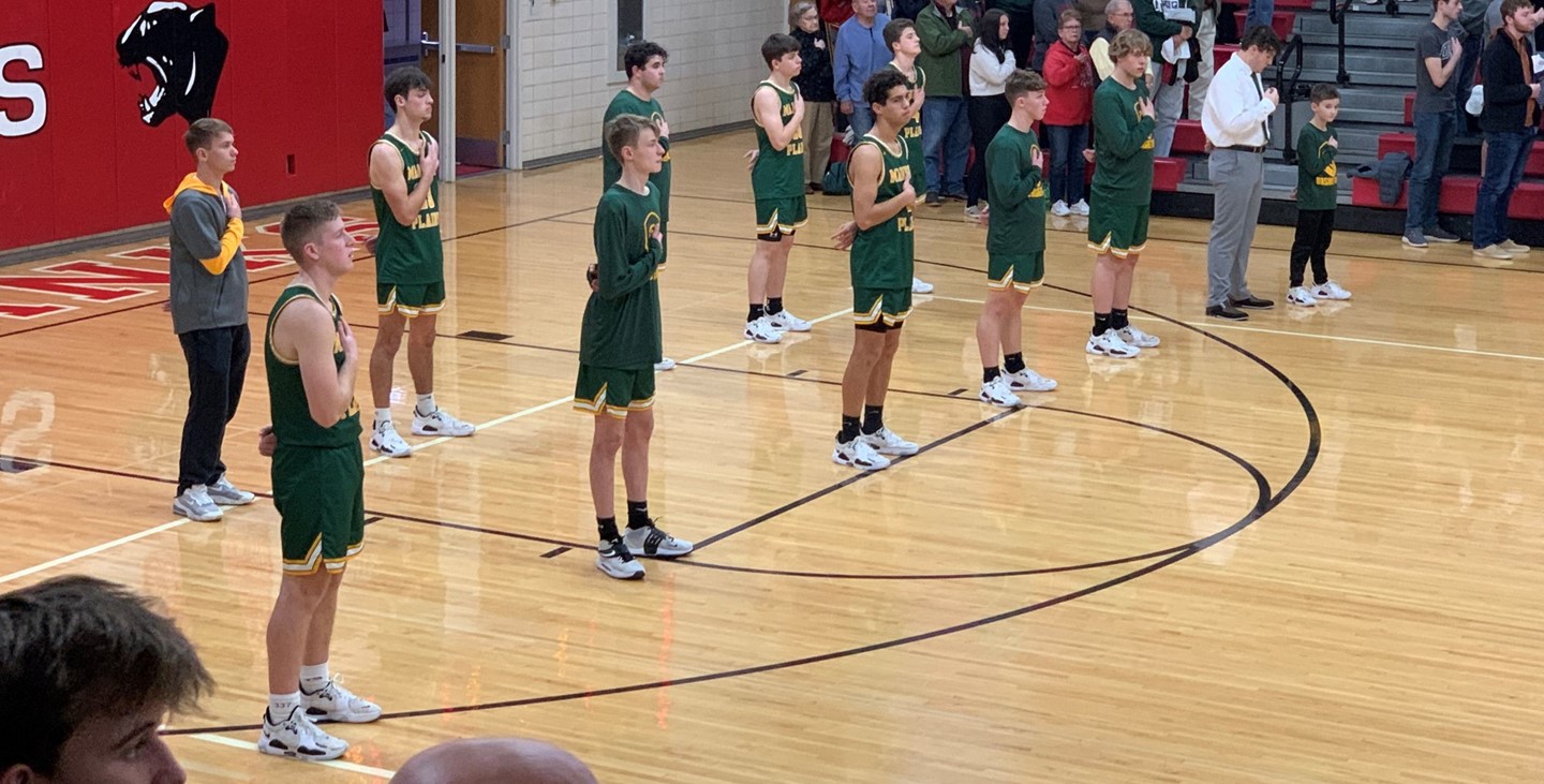 Boys basketball during the national anthem at an away game