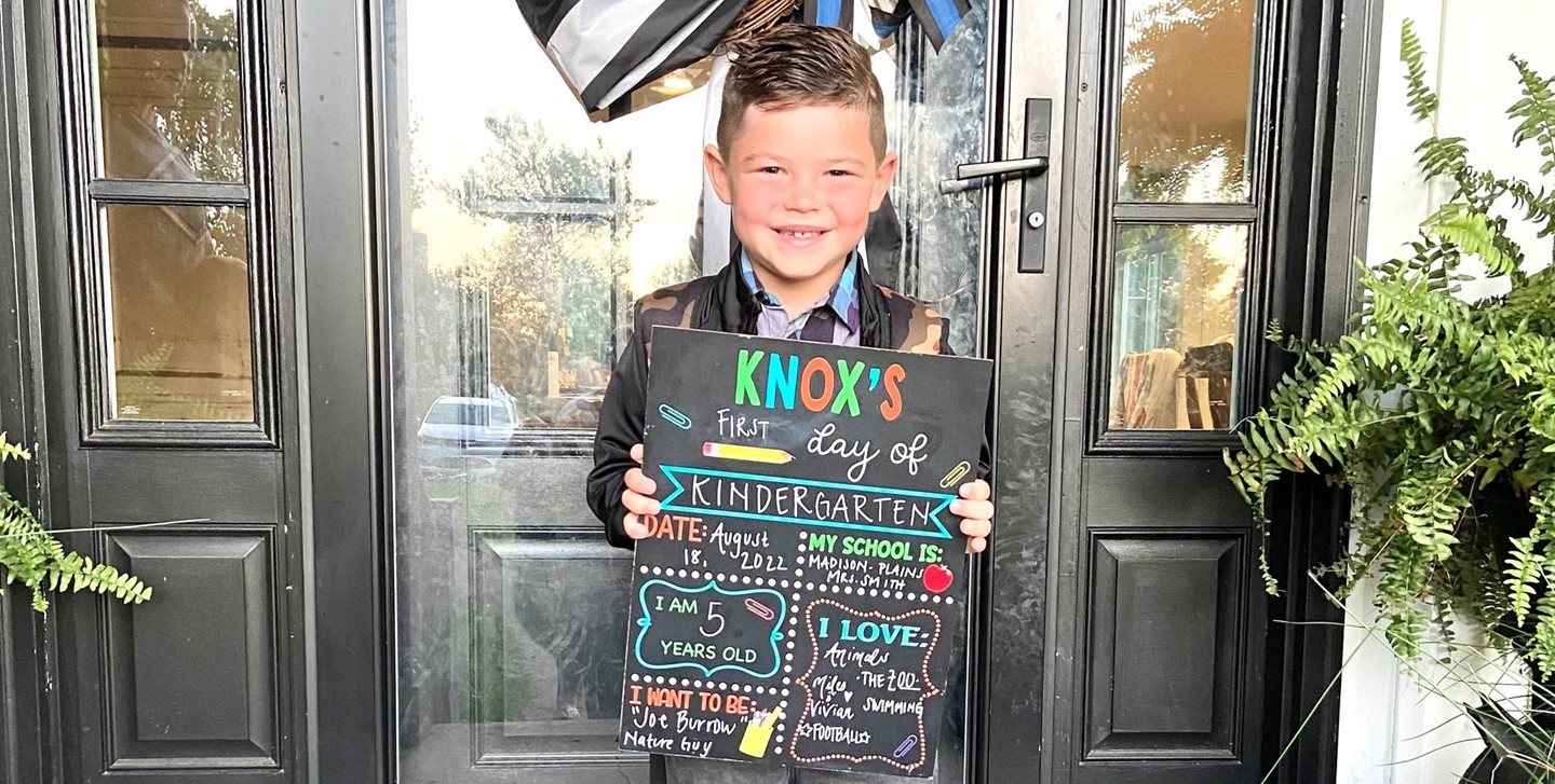 Kindergartener holding his sign for the first day of school