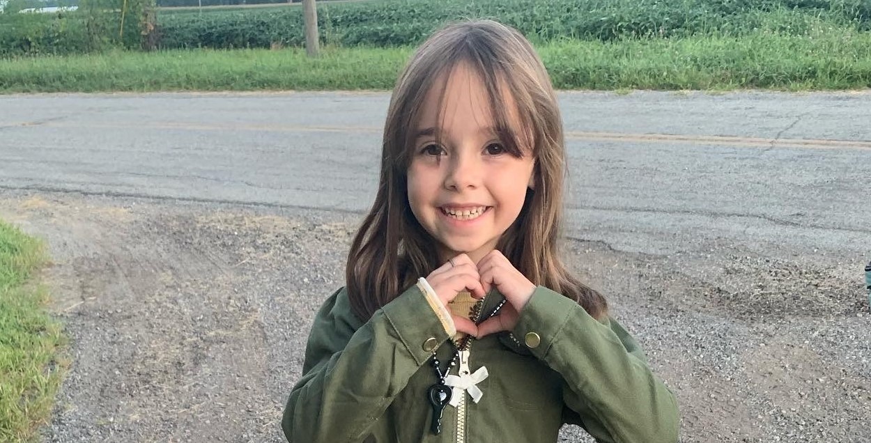 Student on the first day of school with her hands together forming a heart